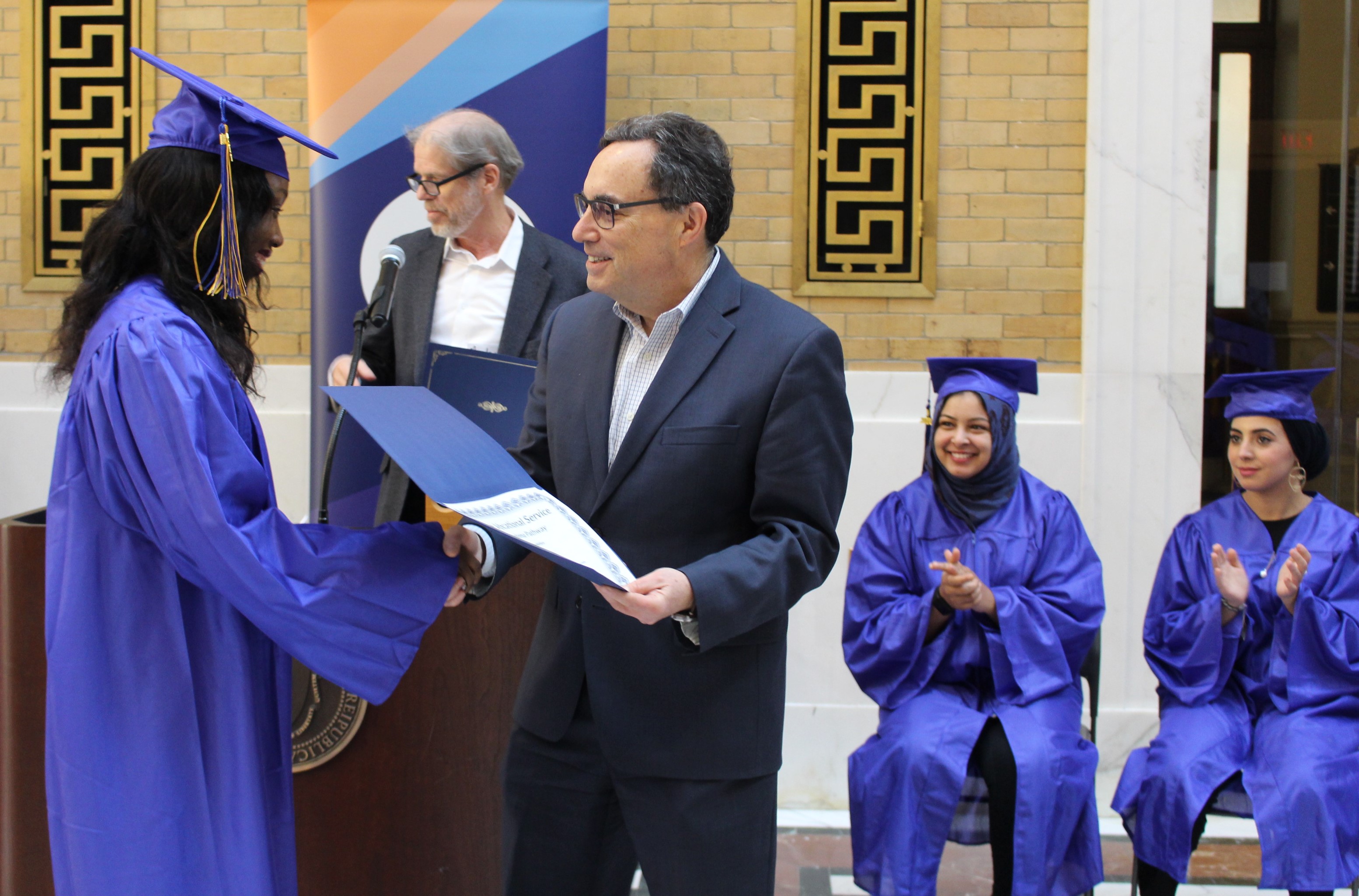Jerry Rubin congratulates a JVS Boston program graduate